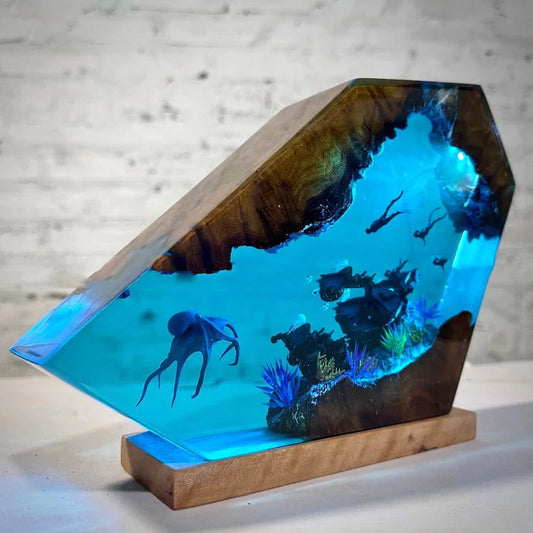 Wooden aquarium with underwater scene including fish and plants on a light gray background